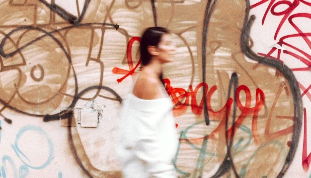 A woman standing in front of a wall covered in graffiti